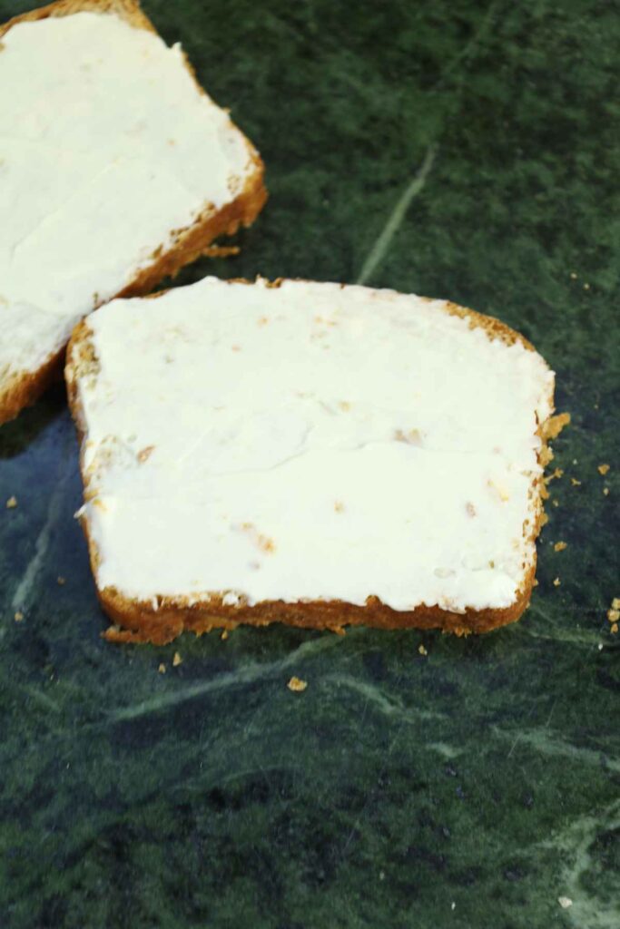 Mayonnaise spread on bread slices.