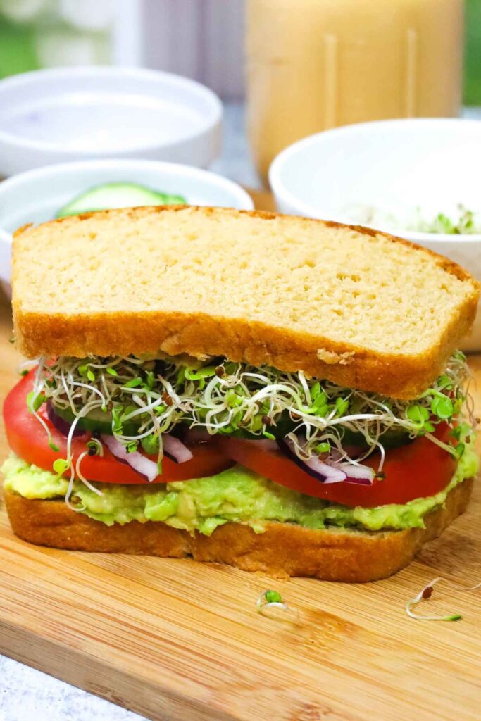 Avocado Sprouts sandwich on a cutting board.