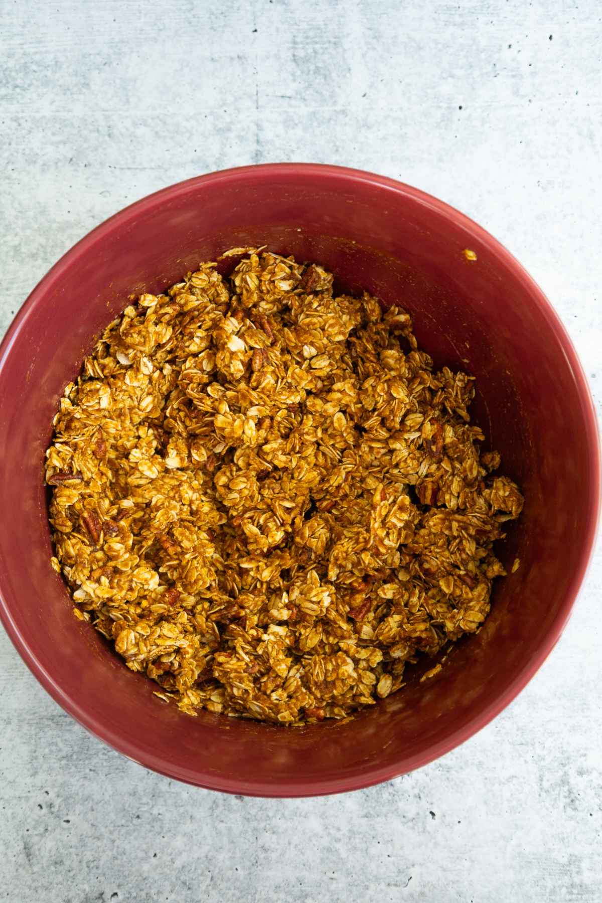 Oat mixture and pumpkin mixture combined in a mixing bowl.